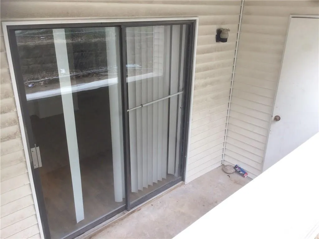 Sliding glass door access to an outdoor area with horizontal siding