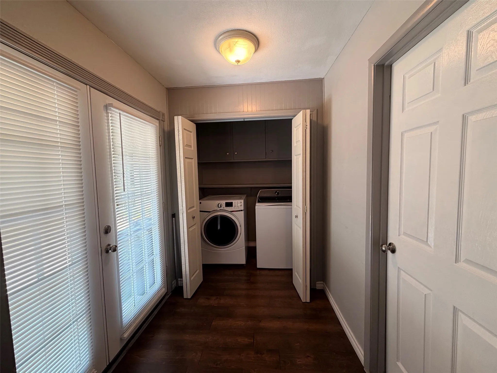Wood-finish flooring with a utility closet featuring built-in cabinetry