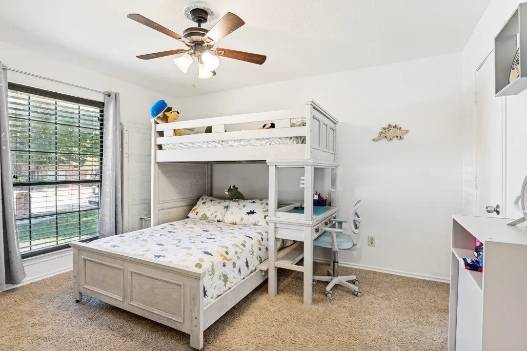 Carpeted room with a ceiling fan, a window with horizontal blinds, and light-toned walls