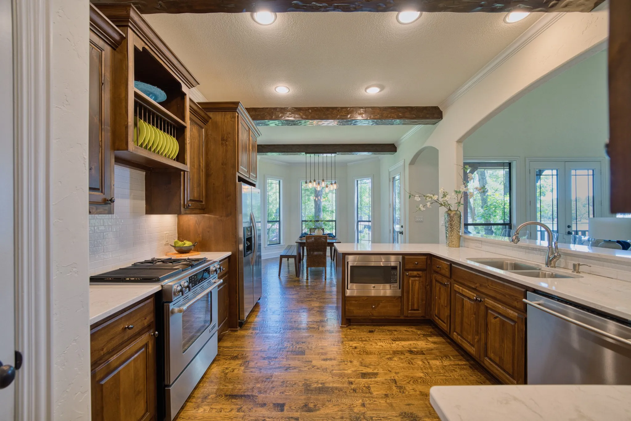 Kitchen featuring wood-finish flooring, recessed lighting, wood cabinetry, stainless steel appliances, and light-toned countertops