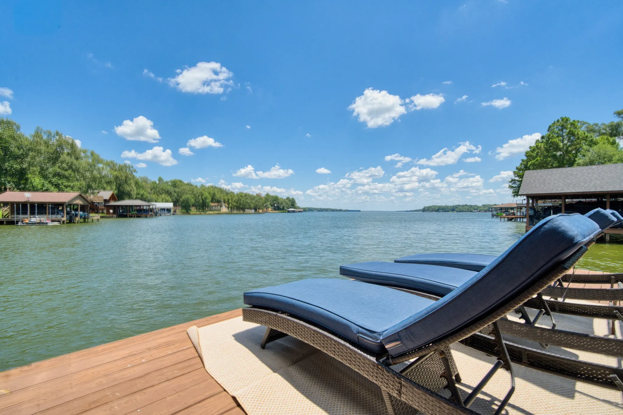Expansive waterfront setting with a substantial dock, open water, and distant treeline