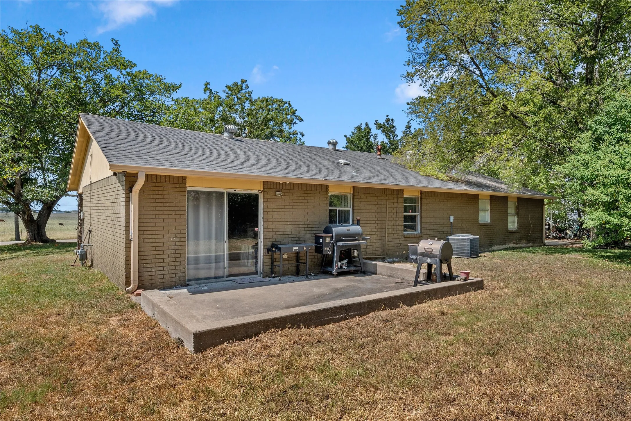 Brick exterior with a gabled roof and gray shingles