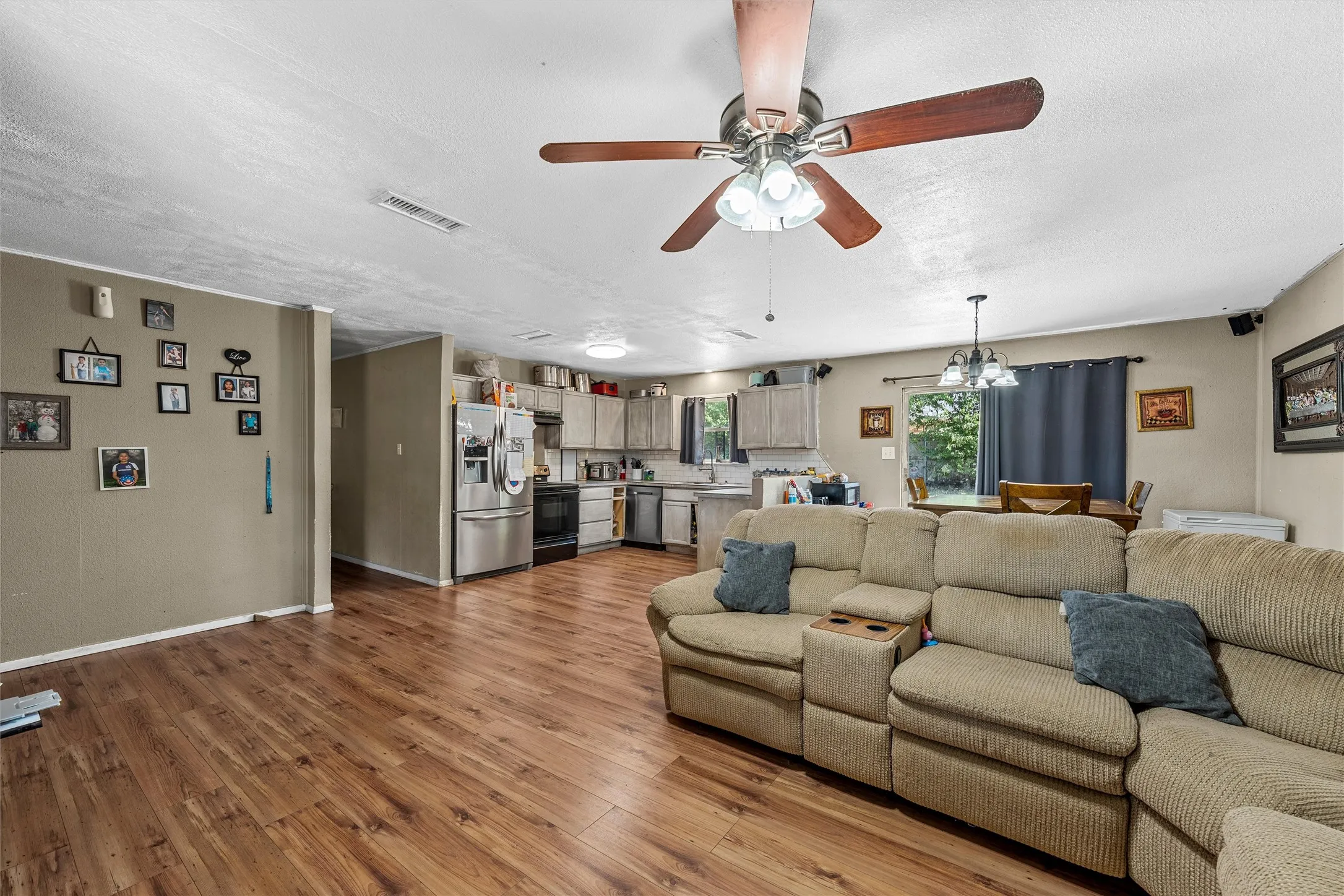Wood-finish flooring throughout, ceiling fan with light fixture, and recessed lighting