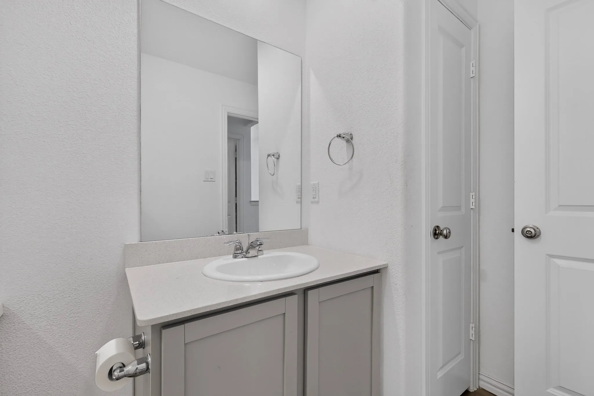 Bathroom vanity with a vessel sink, integrated countertop, and a large wall-mounted mirror