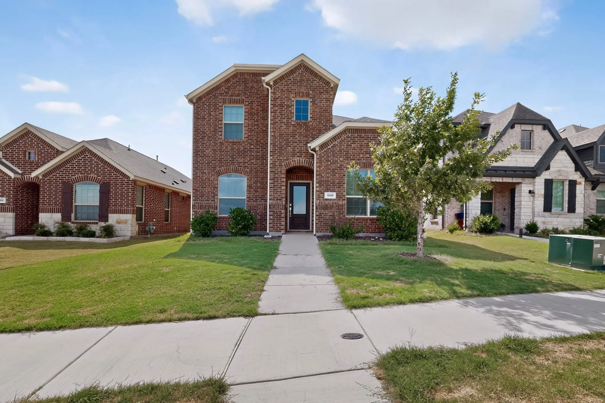 Brick exterior with stone accents, arched entryway, and dark-paneled front door