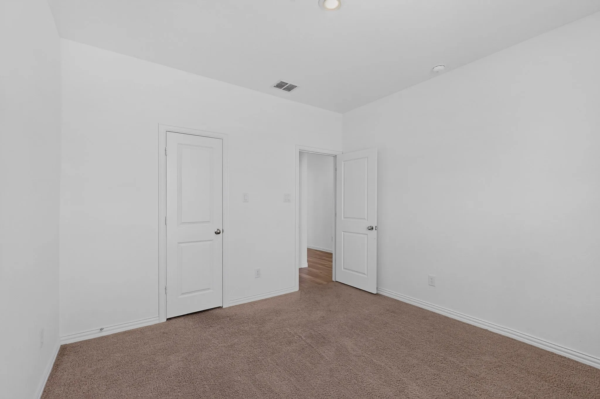 Neutral wall paint, recessed ceiling lighting, two-panel interior doors, and carpet flooring