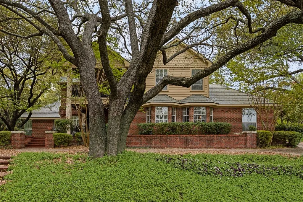 Brick exterior with bay windows and a shingle roof