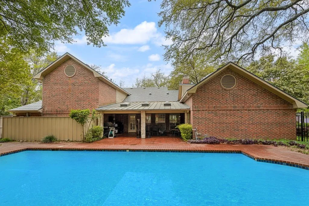 Expansive swimming pool with brick coping