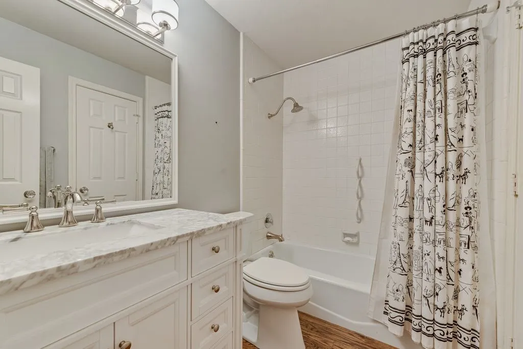 Spa-inspired bathroom featuring a marble-topped vanity with dual sink configuration, polished nickel fixtures, and an expansive framed mirror