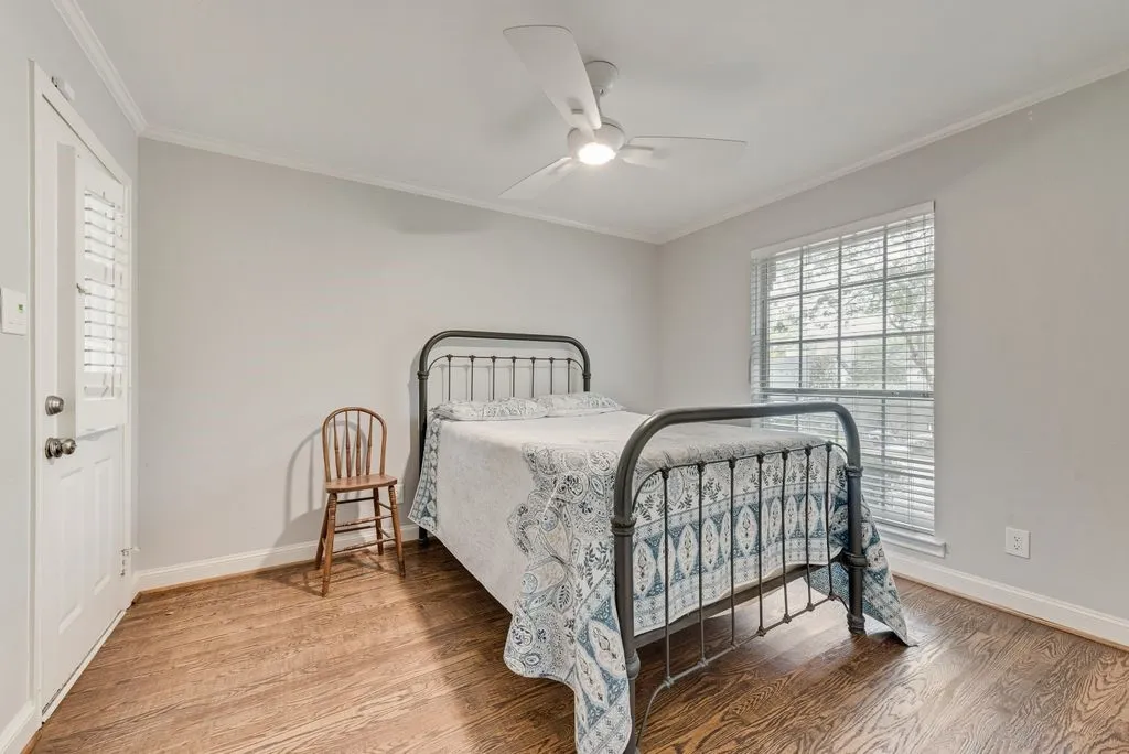 Wood-finish flooring, white ceiling fan, white window blinds, painted walls, and white trim