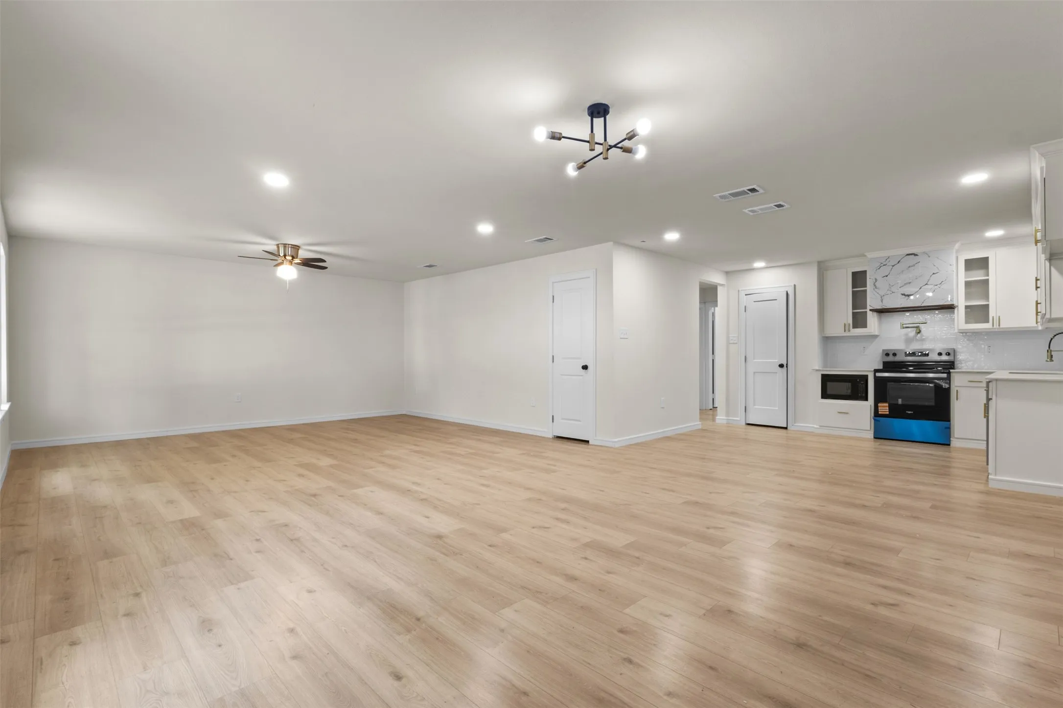 Open-concept living area featuring wood-finish flooring, recessed lighting, and a contemporary ceiling fixture