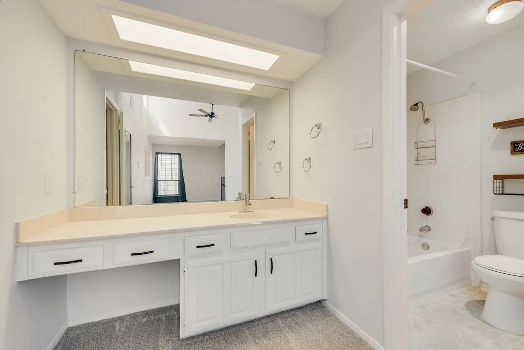 White vanity with a neutral-toned countertop and an integrated sink