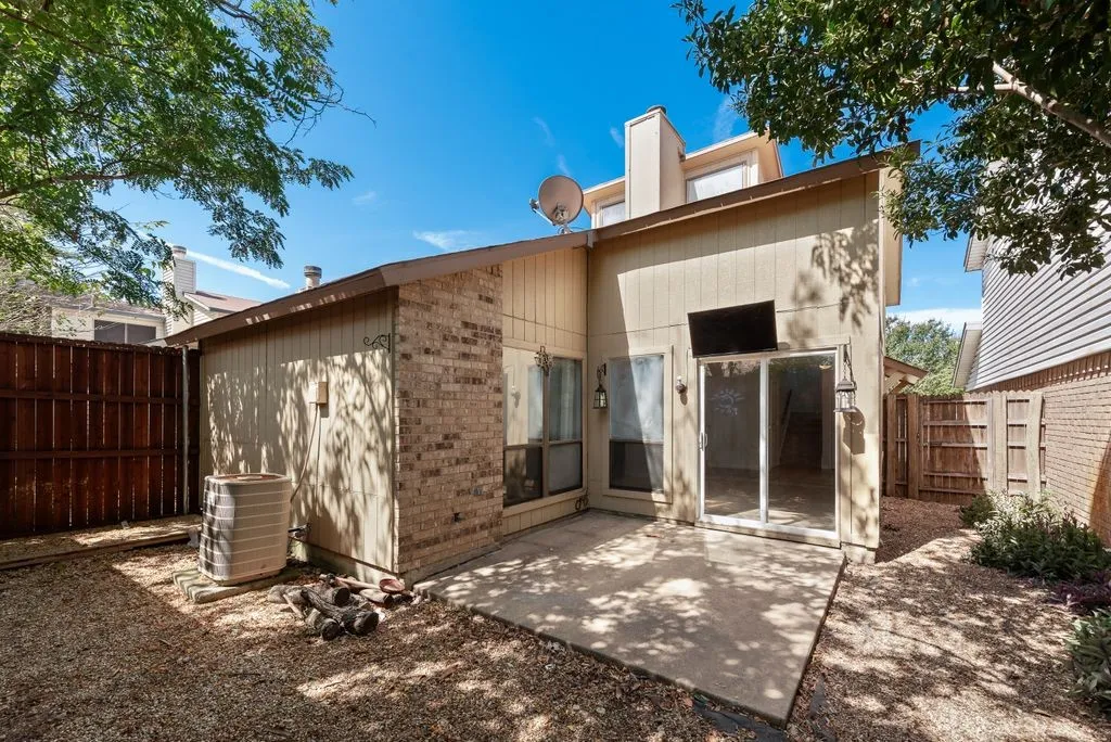 Private patio with sliding glass door access, brick and siding exterior, and gravel landscaping