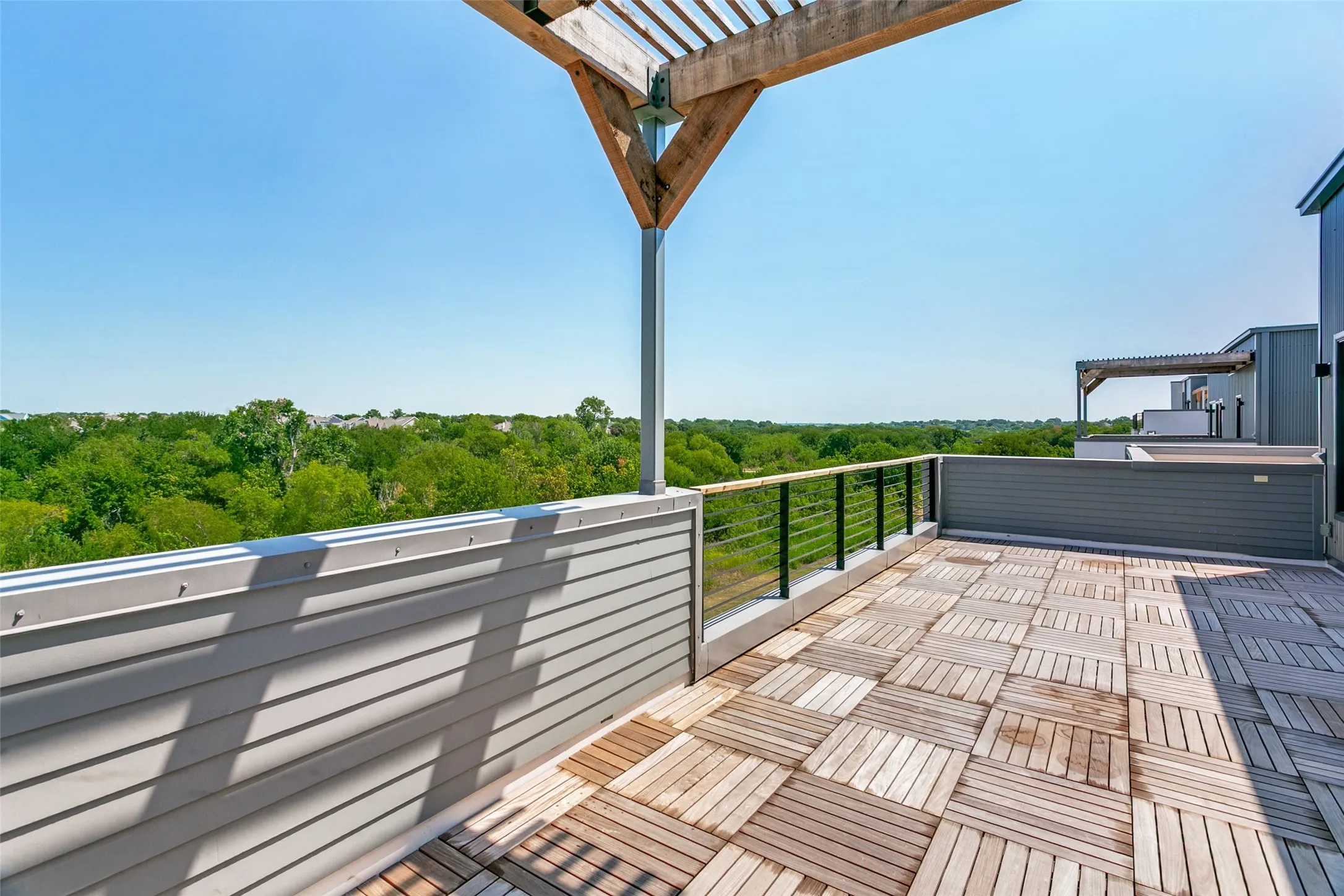 Expansive third-floor outdoor retreat featuring a covered pergola and peaceful views, perfect for entertaining or unwinding.