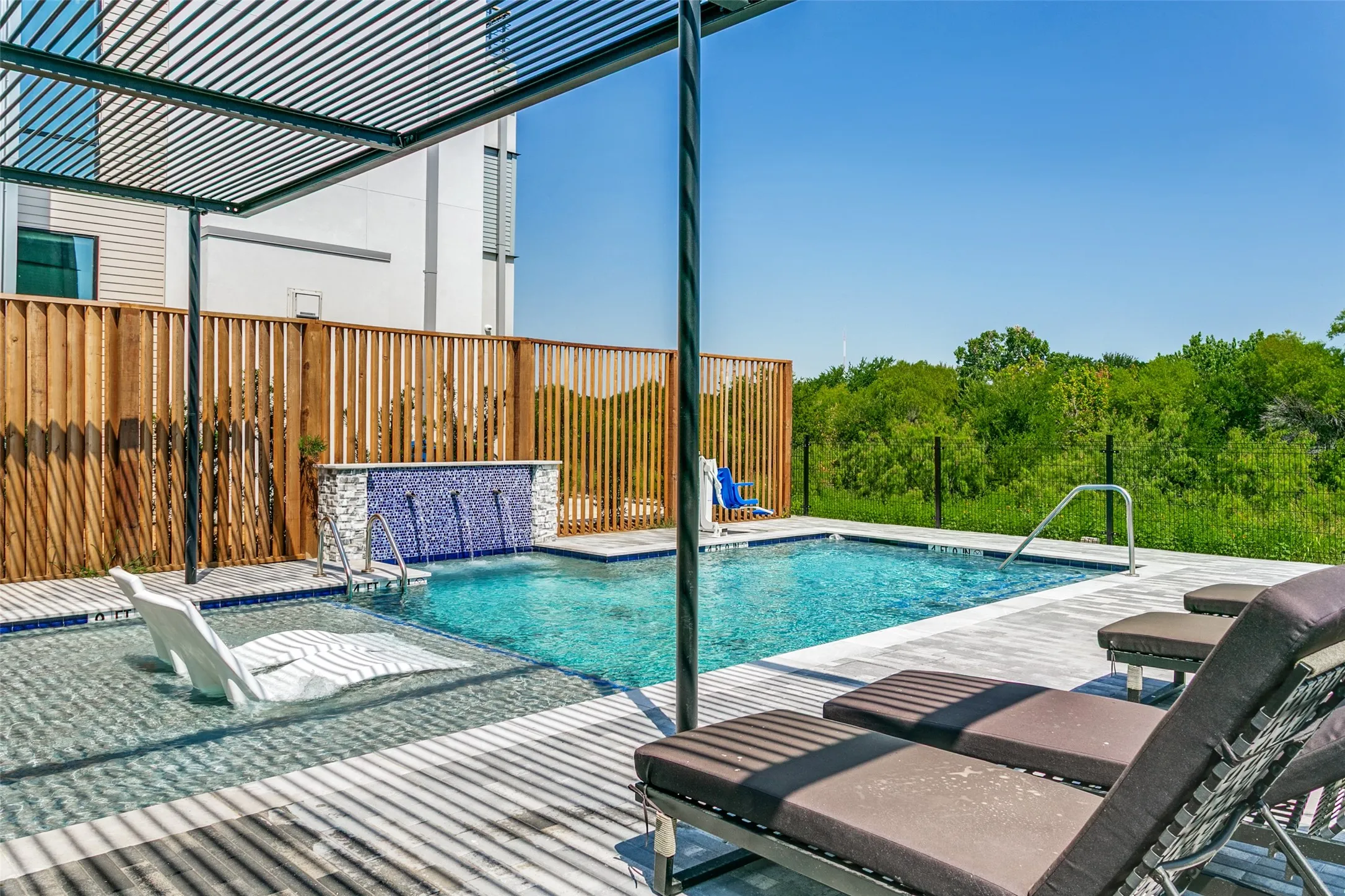 Private community pool overlooking the scenic blue trail and greenbelt, creating a tranquil setting for relaxation.