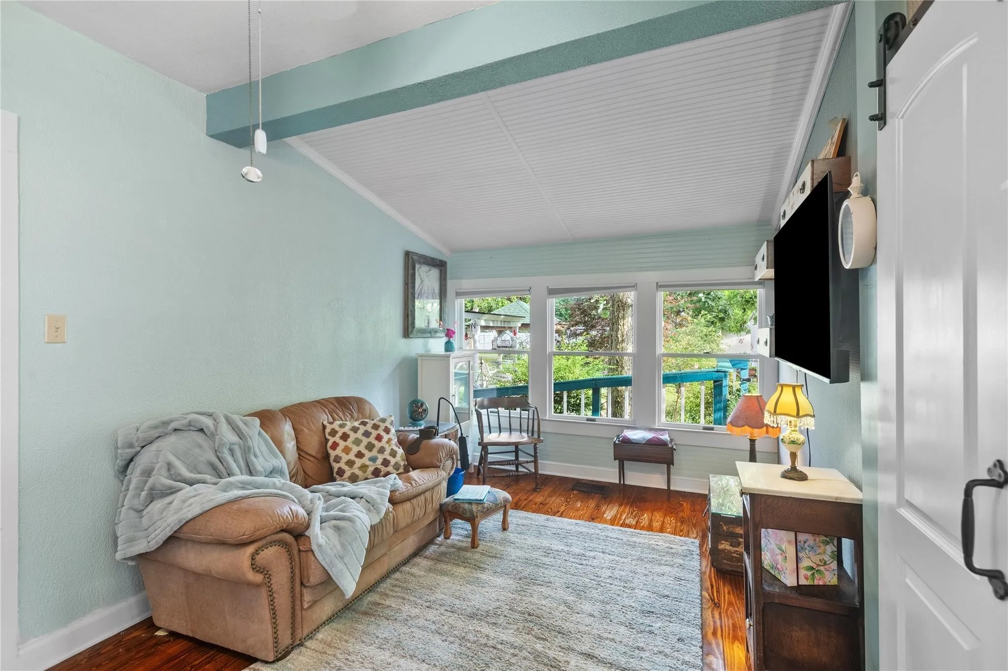 Wood-finish flooring, white trim, and multiple windows