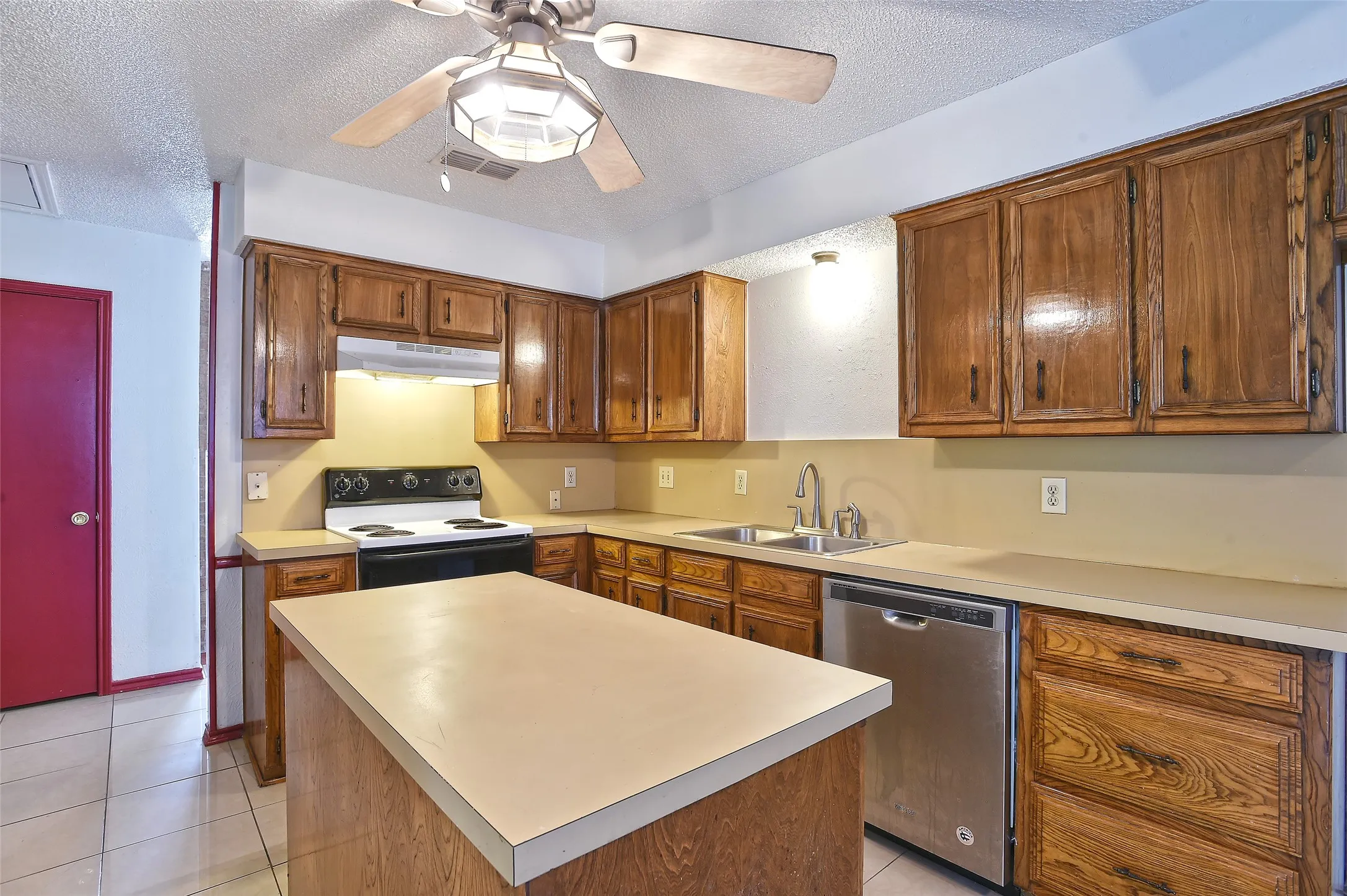 The island adds extra storage and work surface.  Notice the ceiling fan!  What a great feature to have when cooking and baking in the summertime.
