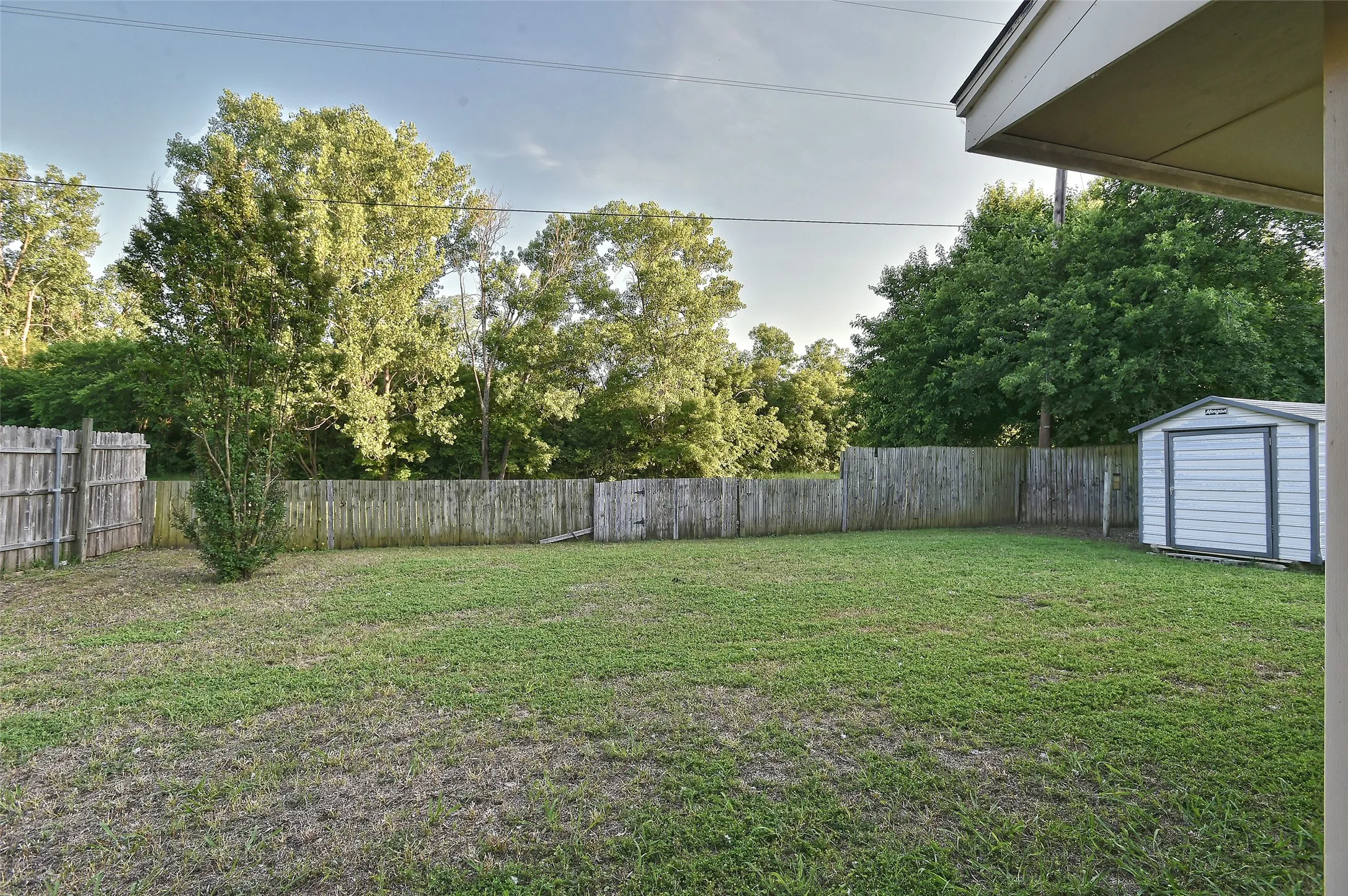 The large backyard has a storage shed.