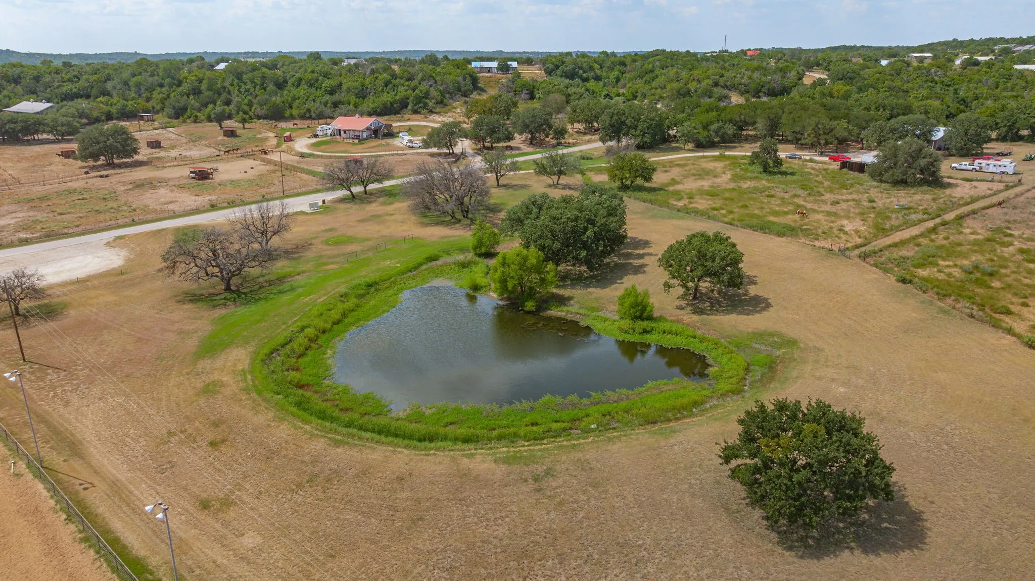 Community park and pond next to outdoor lighted arena