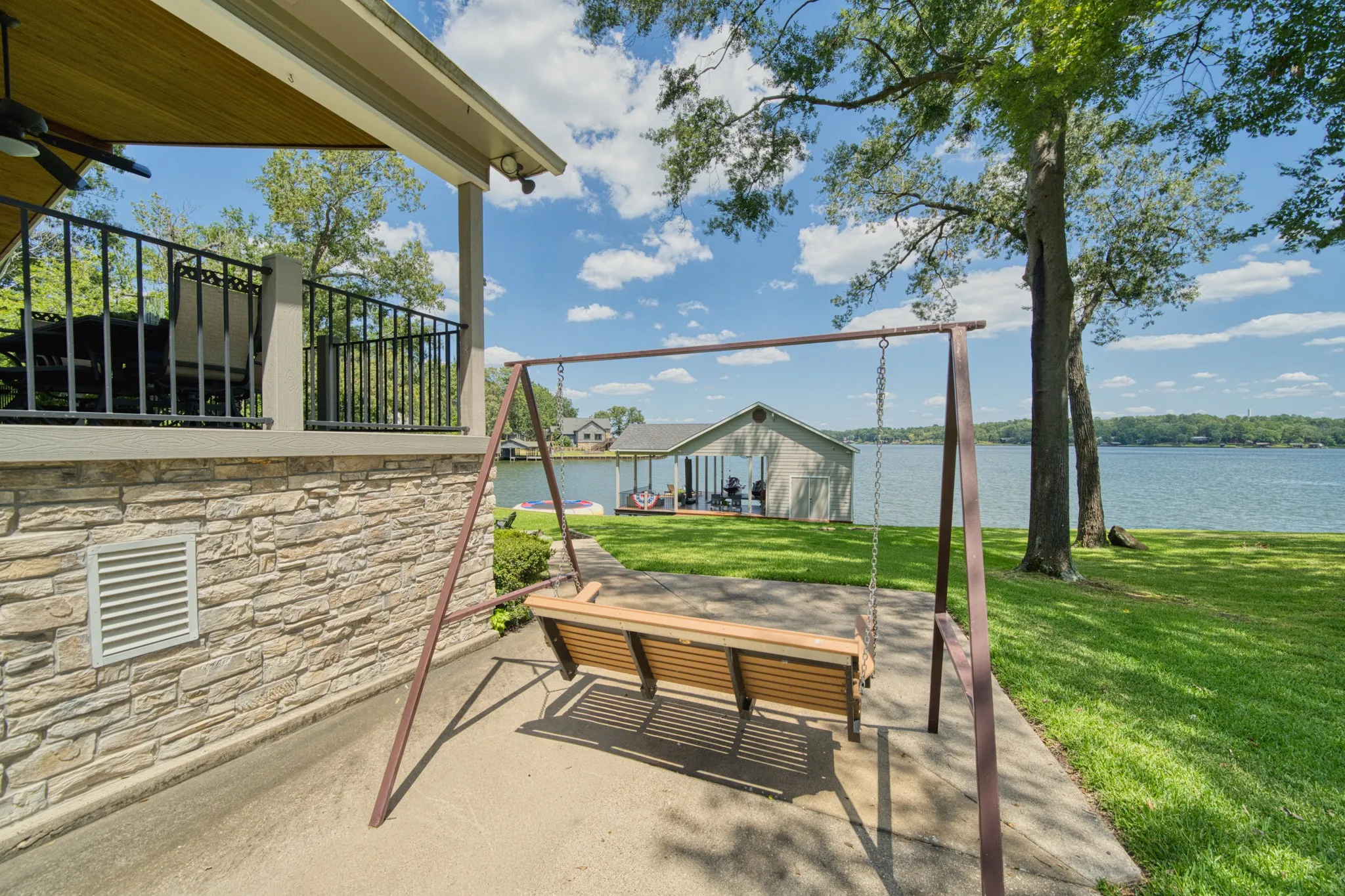 Expansive waterfront setting with mature trees and a manicured lawn