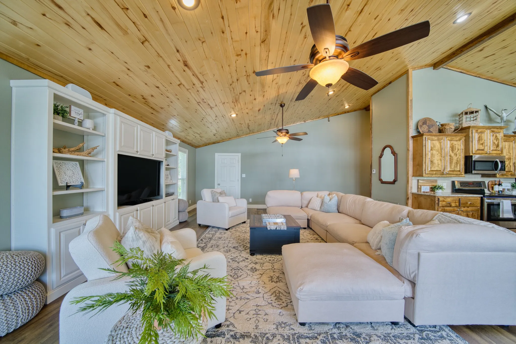 Vaulted wood-paneled ceiling, recessed lighting, and dual ceiling fans