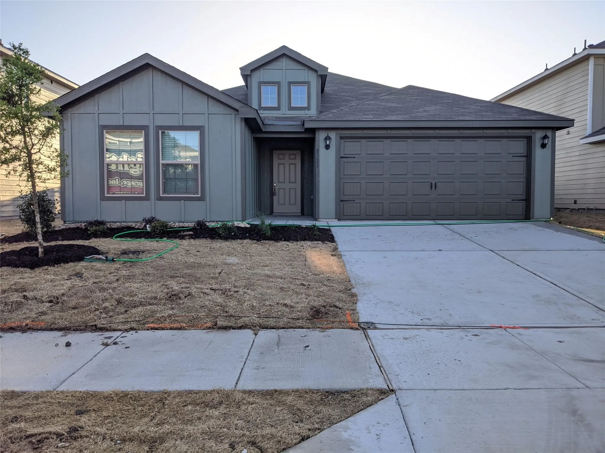 Single-story residence featuring a two-car garage, concrete driveway, and a front entry with a dormer accent