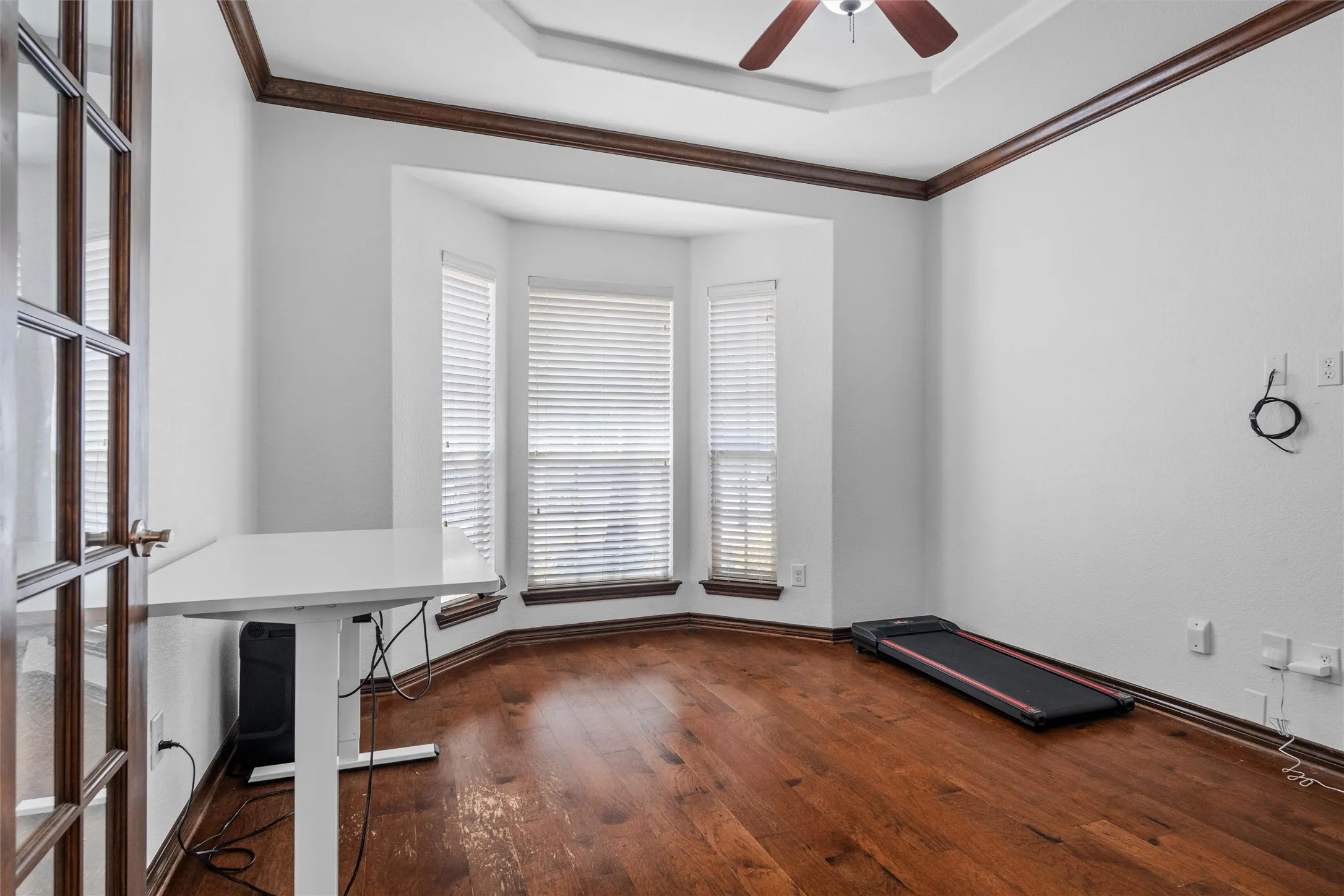 French doors, wood-finish flooring, bay windows with blinds, tray ceiling, and crown molding