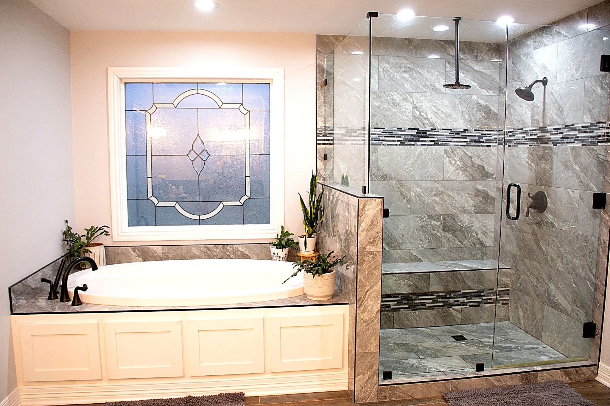 Built-in soaking tub with a decorative window and walk in shower