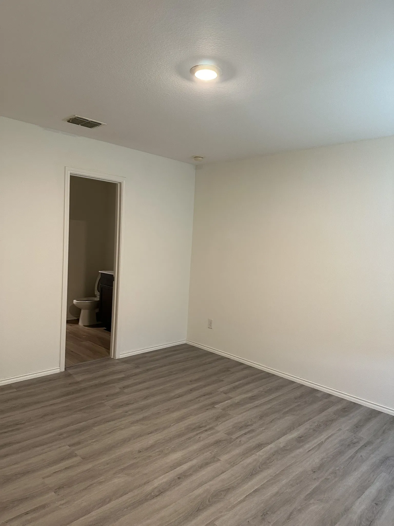 Spare room featuring wood finished floors and a textured ceiling