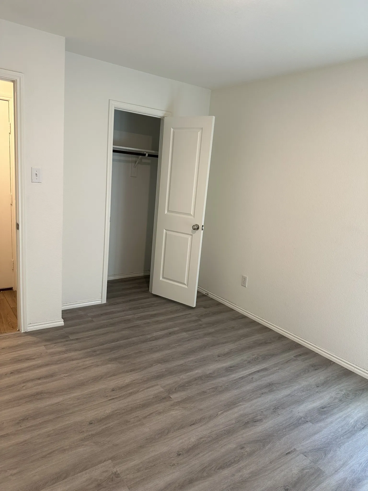 Unfurnished bedroom with wood finished floors and a closet