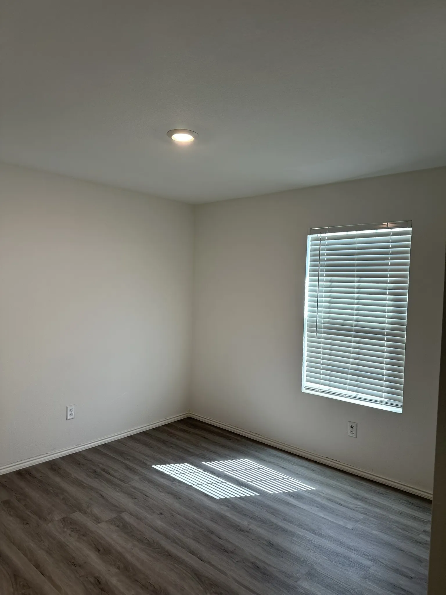 Unfurnished room with wood finished floors and baseboards