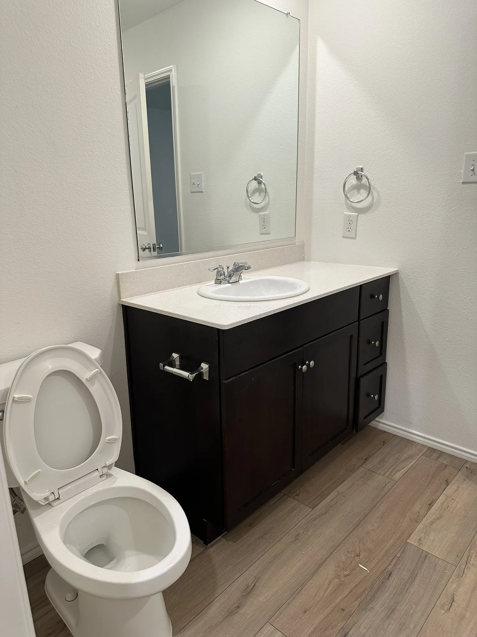 Bathroom with wood finished floors, vanity, and a textured wall