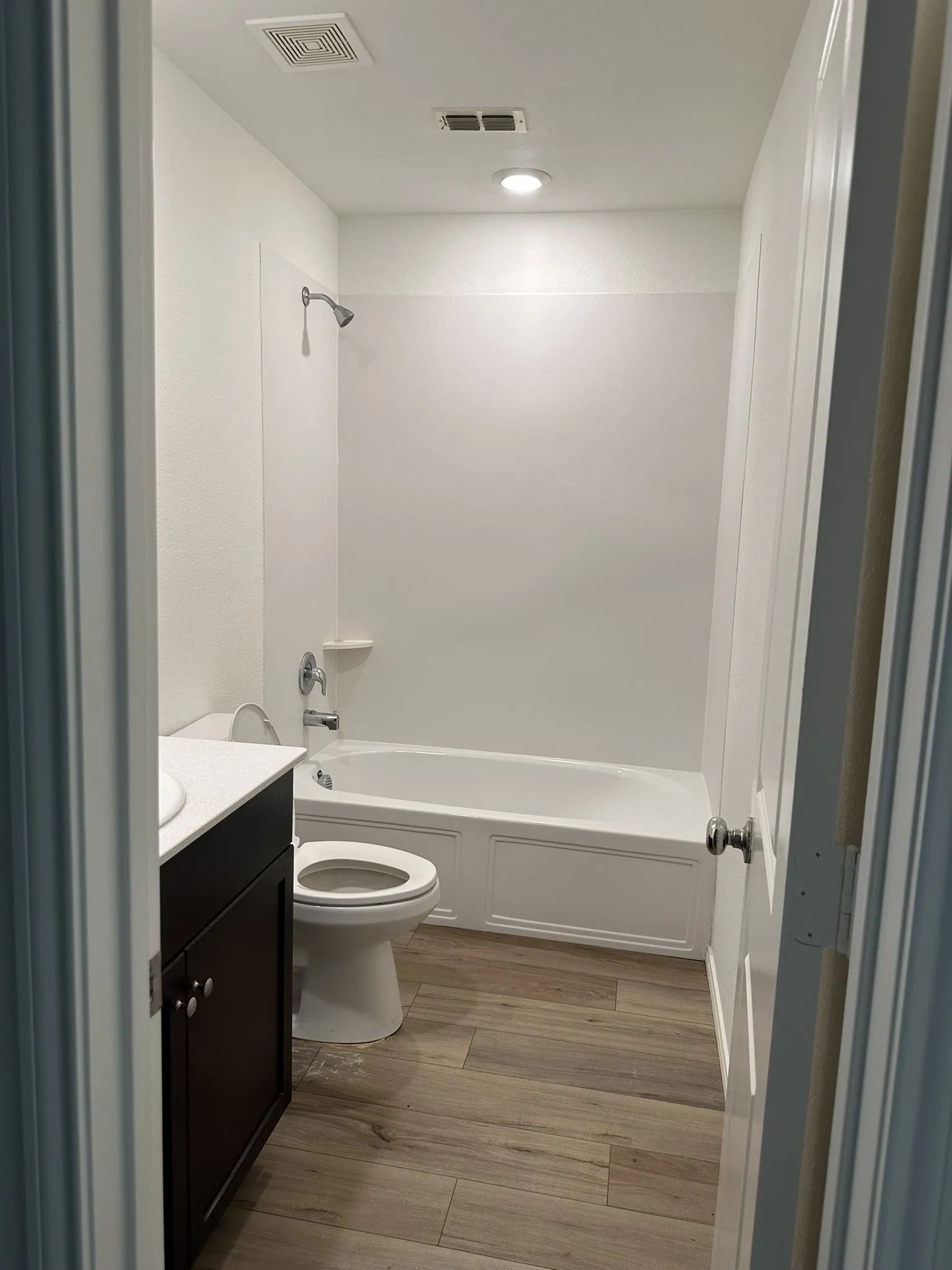 Bathroom with vanity, wood finished floors, and shower / tub combination