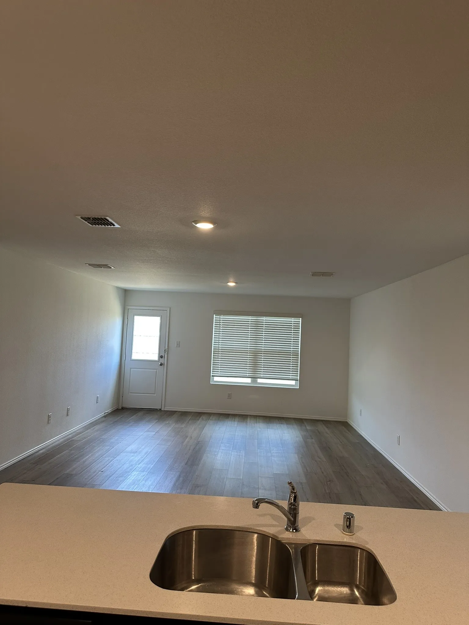 Kitchen with open floor plan, wood finished floors, and light countertops