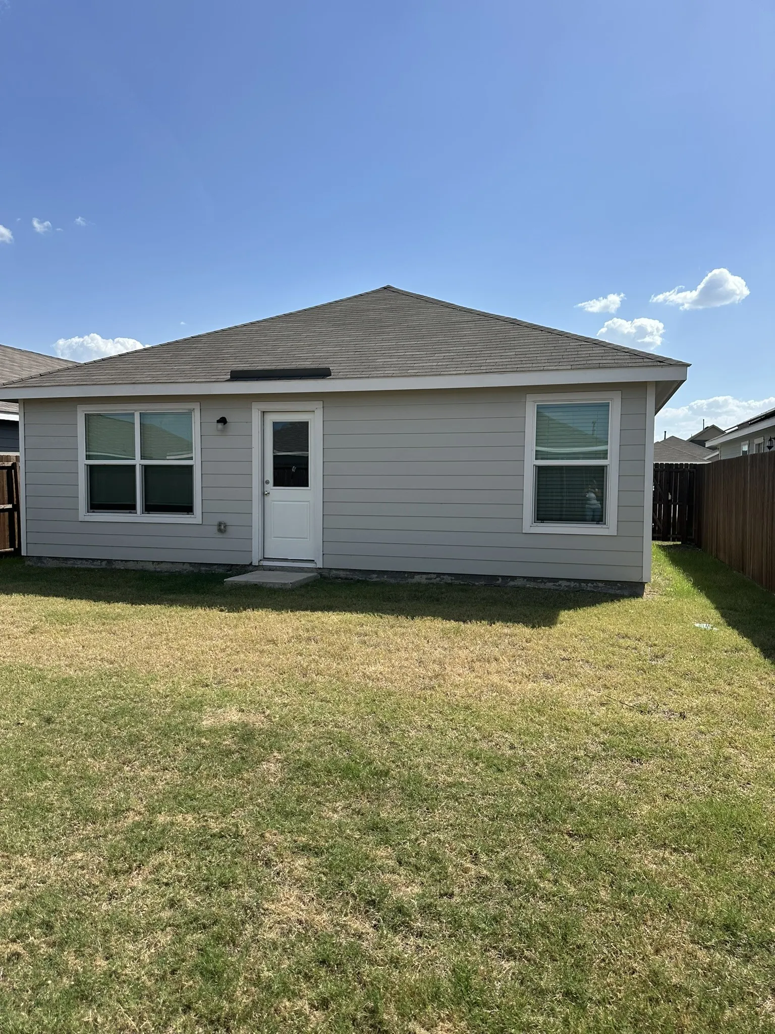 Back of property featuring a shingled roof