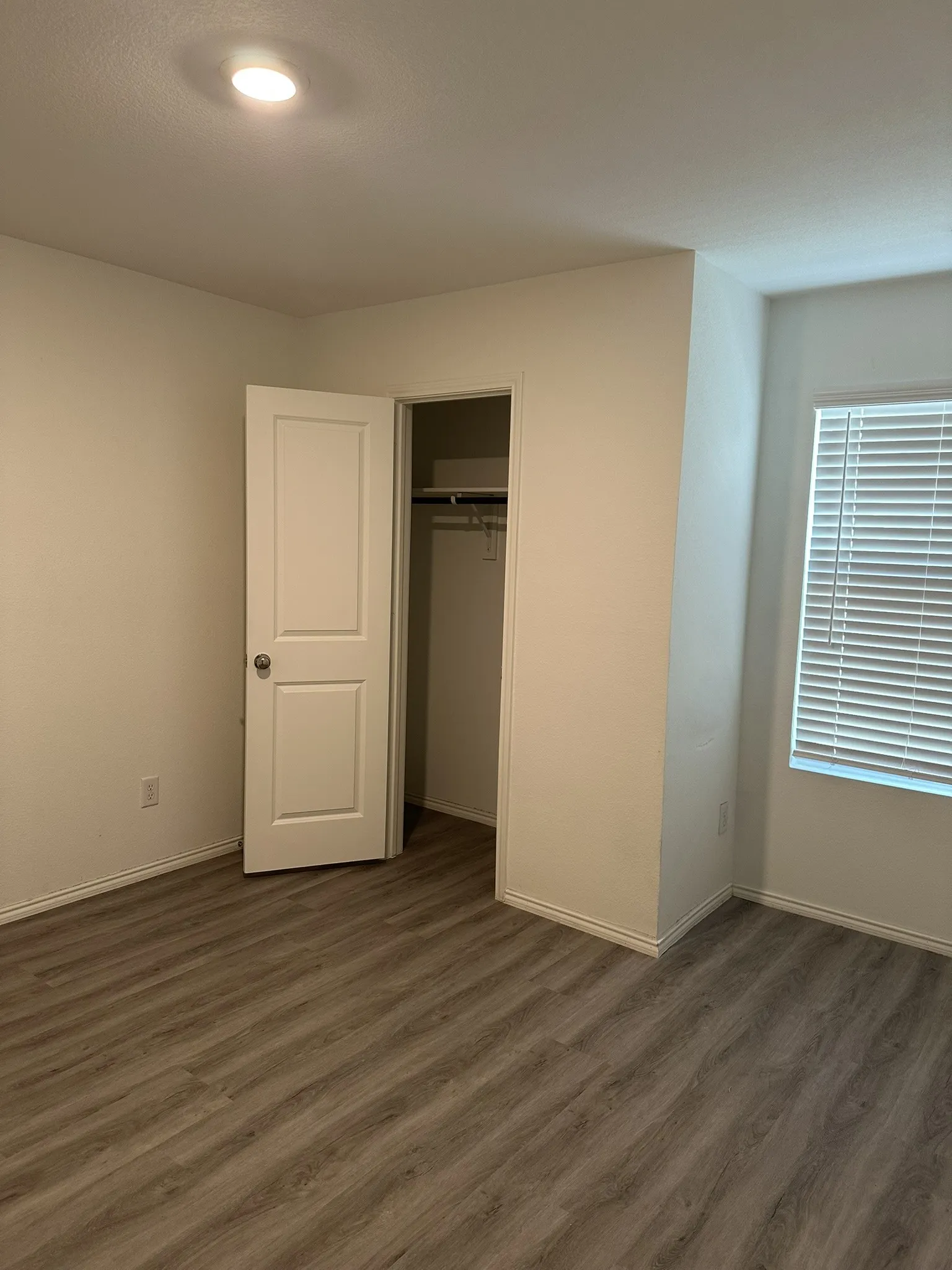 Unfurnished bedroom featuring dark wood-style floors and a closet