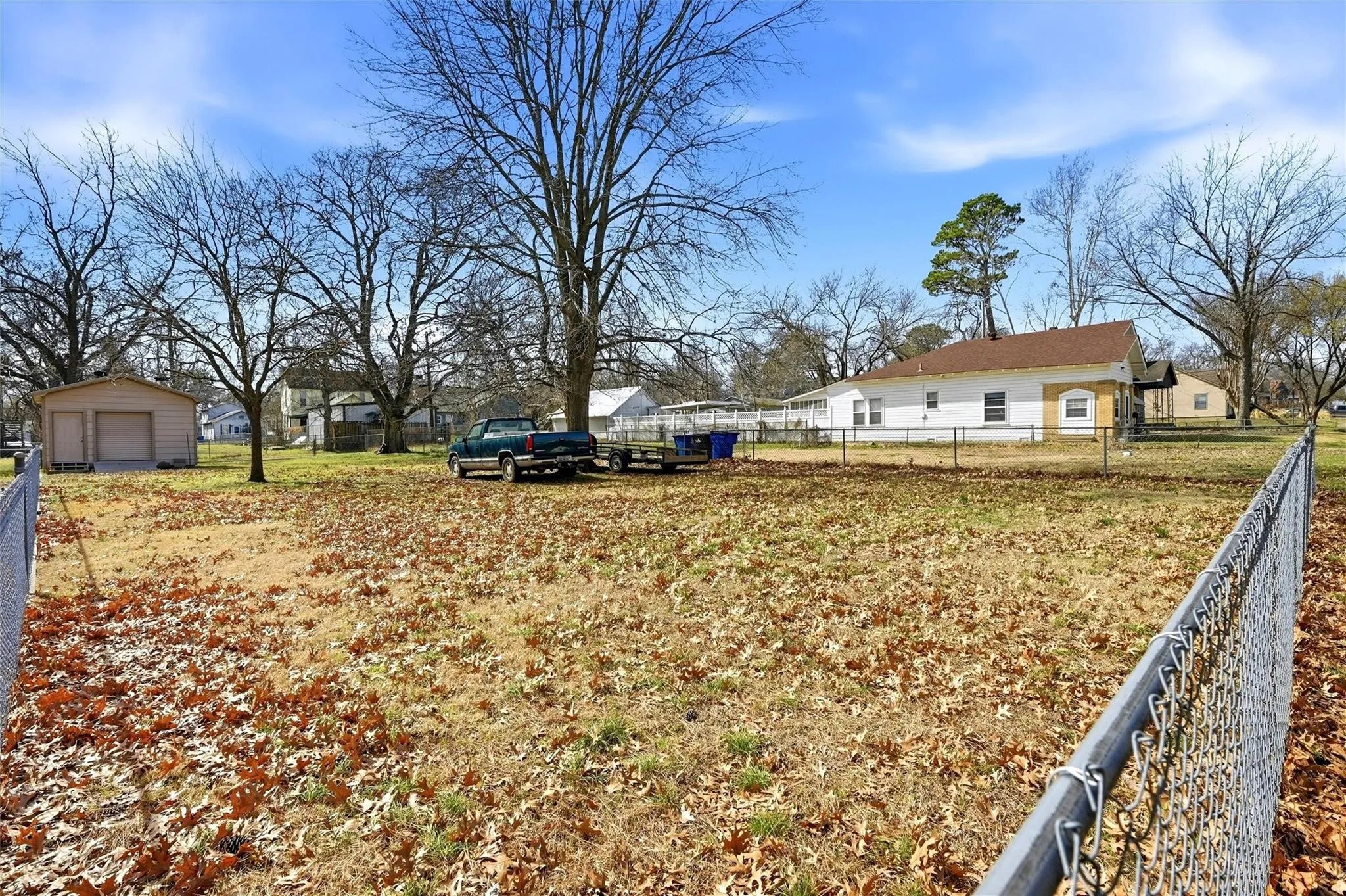Chain-link fence enclosing a spacious yard with a detached two-car garage