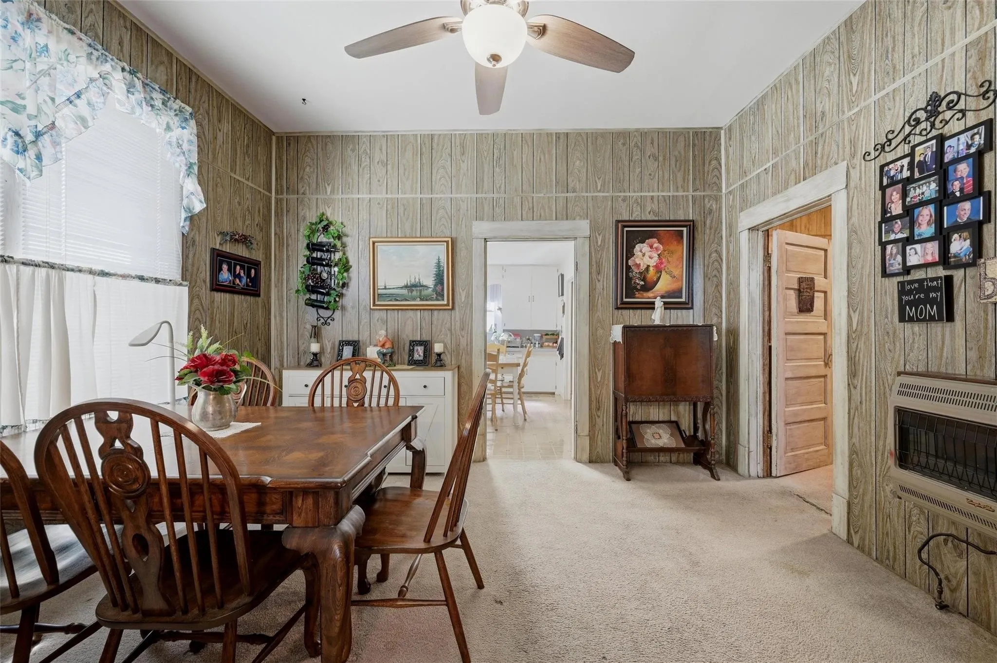 Wall paneling with trim, ceiling fan, and carpeted flooring