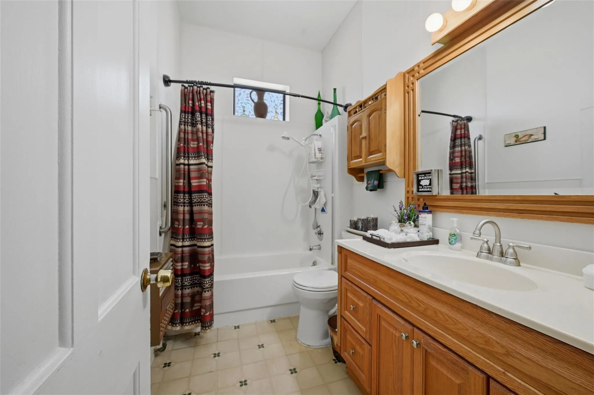 Full vanity with wood-finish cabinetry, integrated sink, and chrome faucet