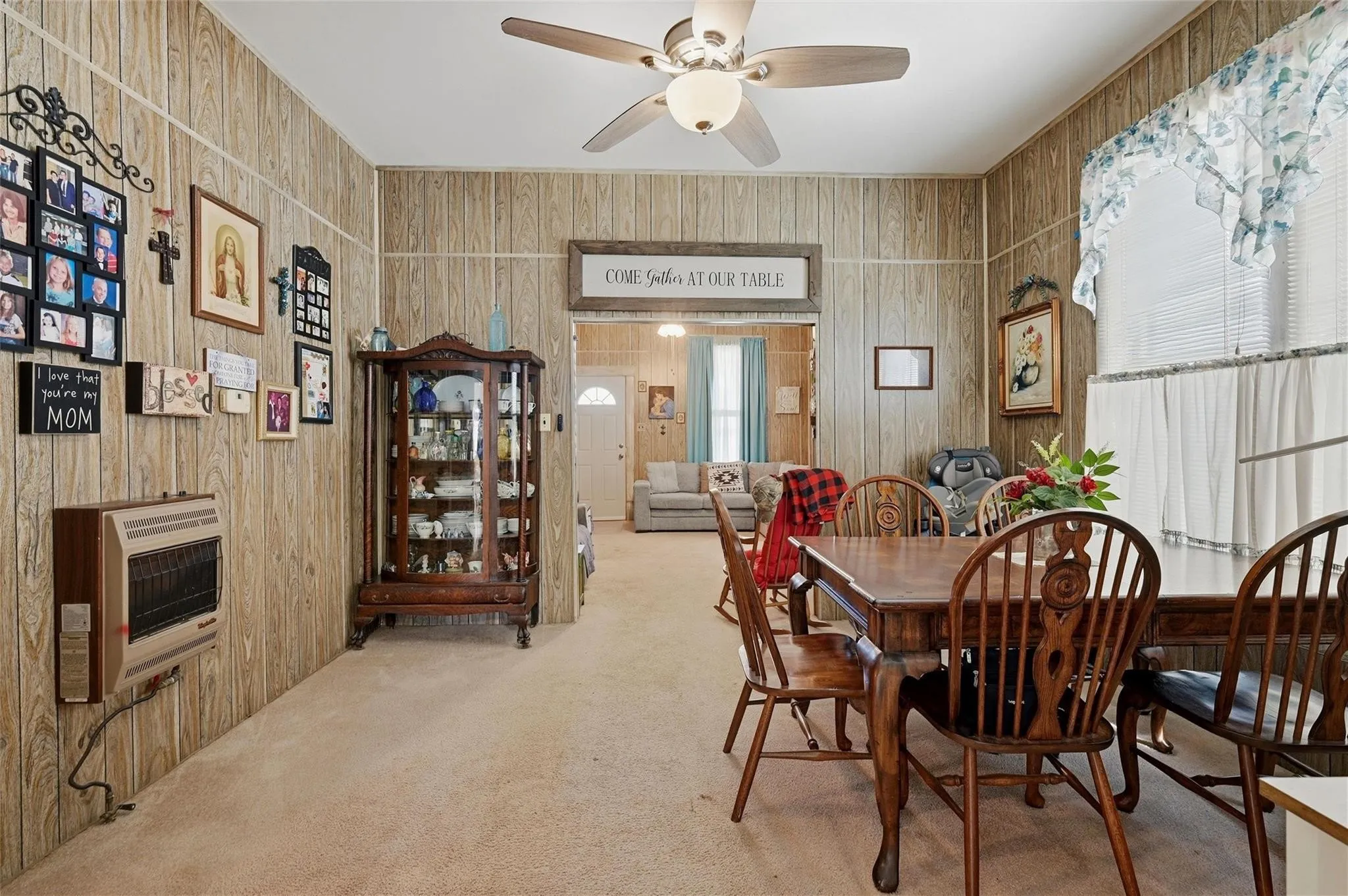 Recessed ceiling fan, wood-finish wall paneling, wall-mounted heater, and light-toned carpeting