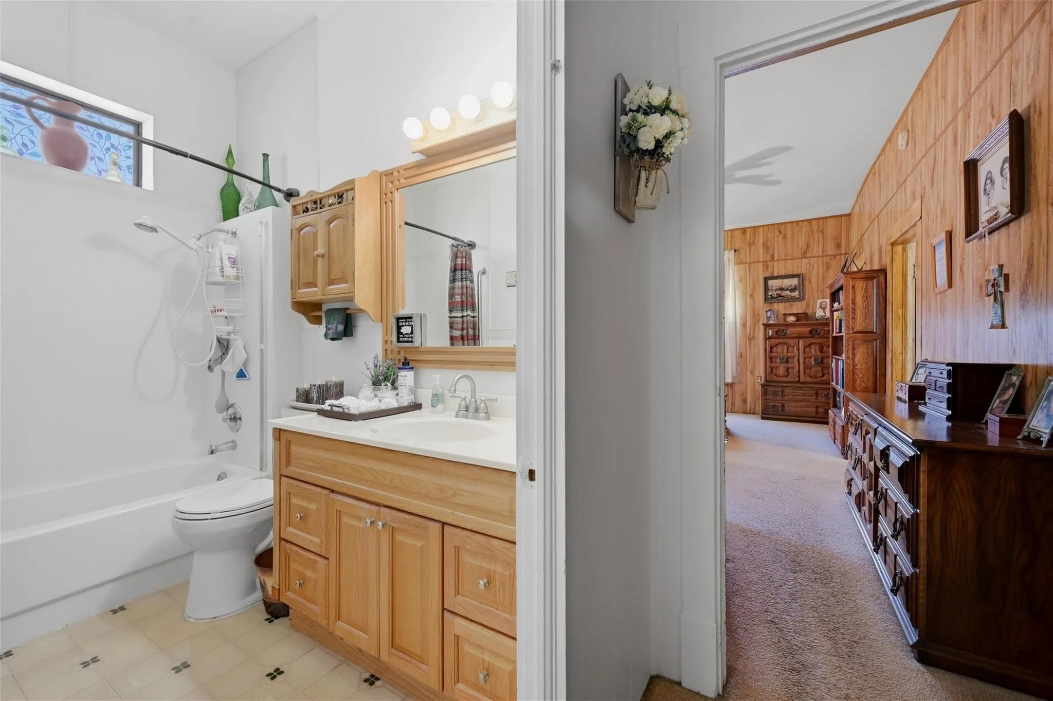 Bathroom with wood-finish vanity, integrated sink, and overhead lighting