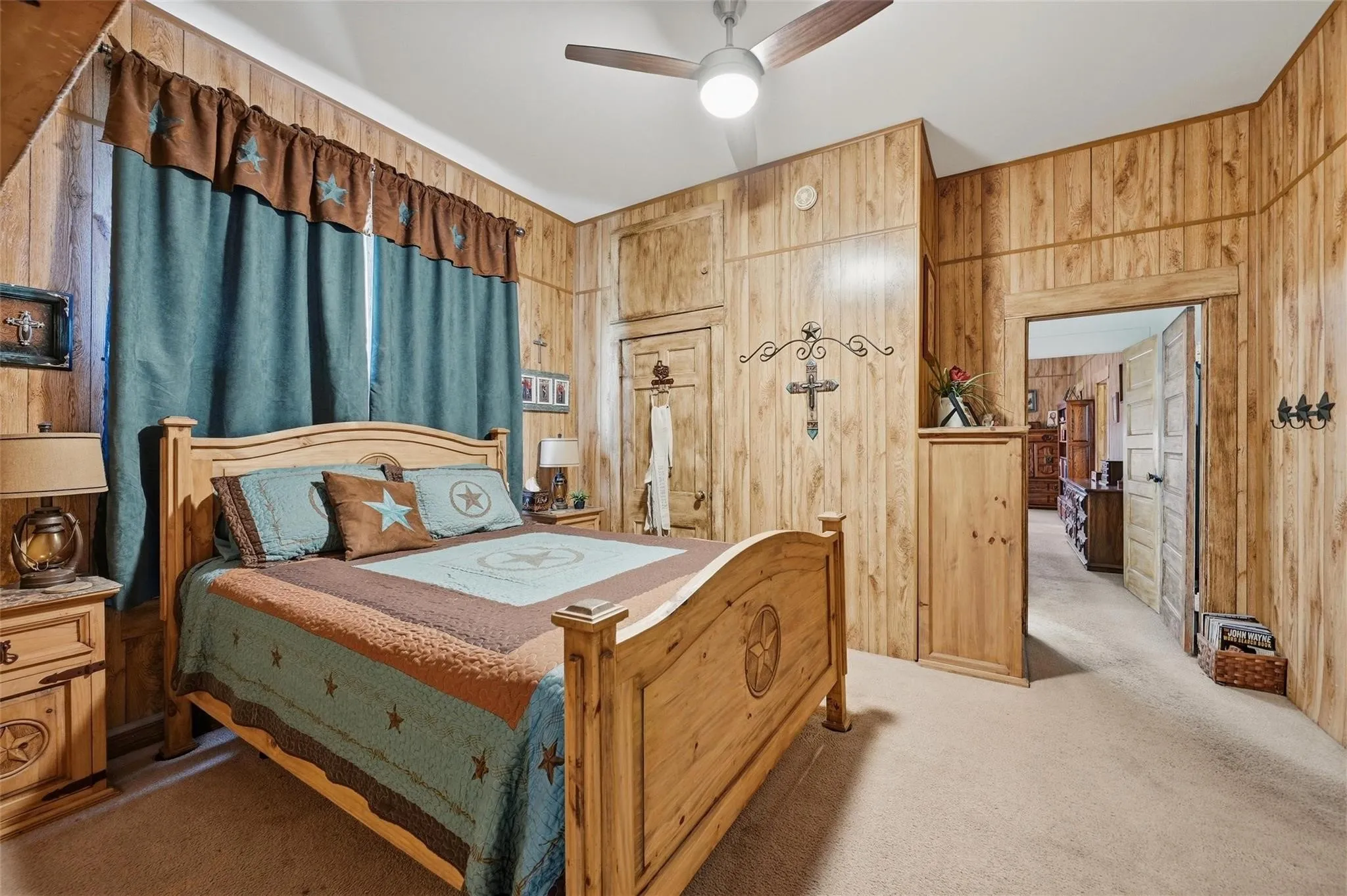 Wood-panel walls, carpeted flooring, and a ceiling fan with integrated lighting