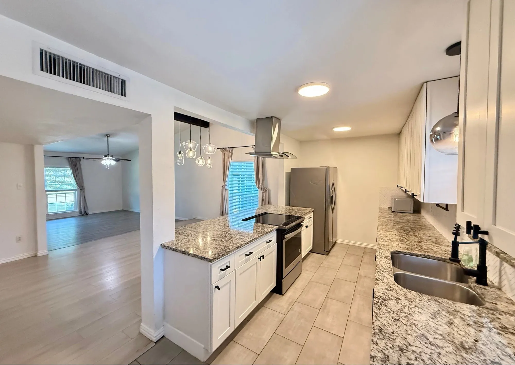 Kitchen with light wood-finish cabinetry, stainless steel appliances, and granite countertops