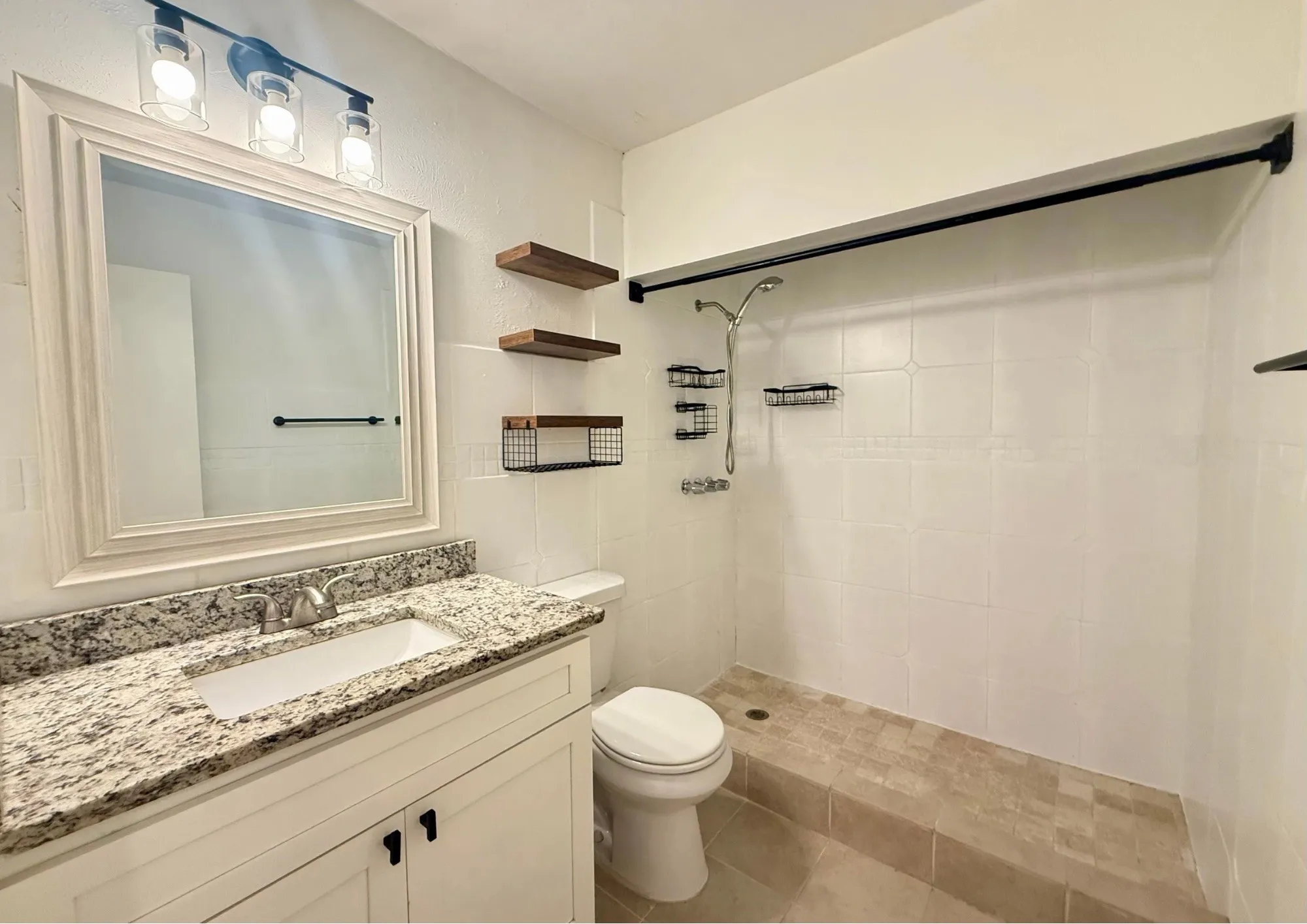 Bathroom with a built-in shower featuring tiled walls and a handheld shower fixture