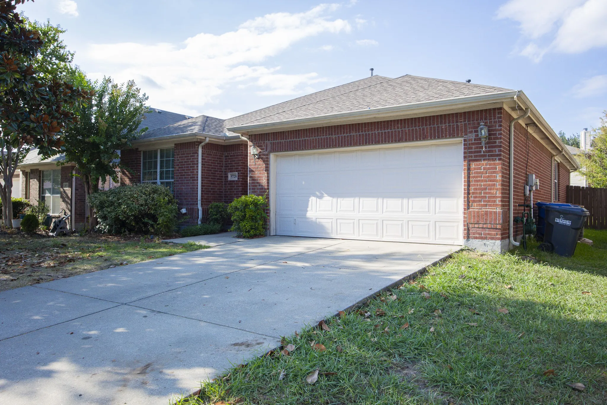 Brick exterior with a paneled garage door and a concrete driveway