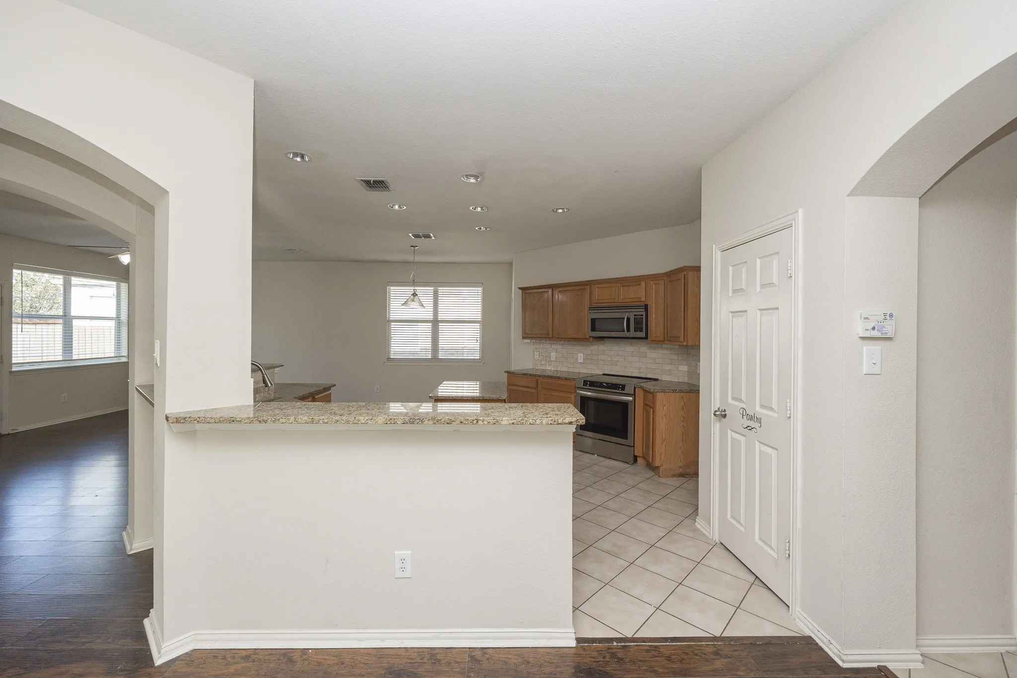 Kitchen with tile flooring, wood cabinetry, stainless steel oven, and a built-in microwave