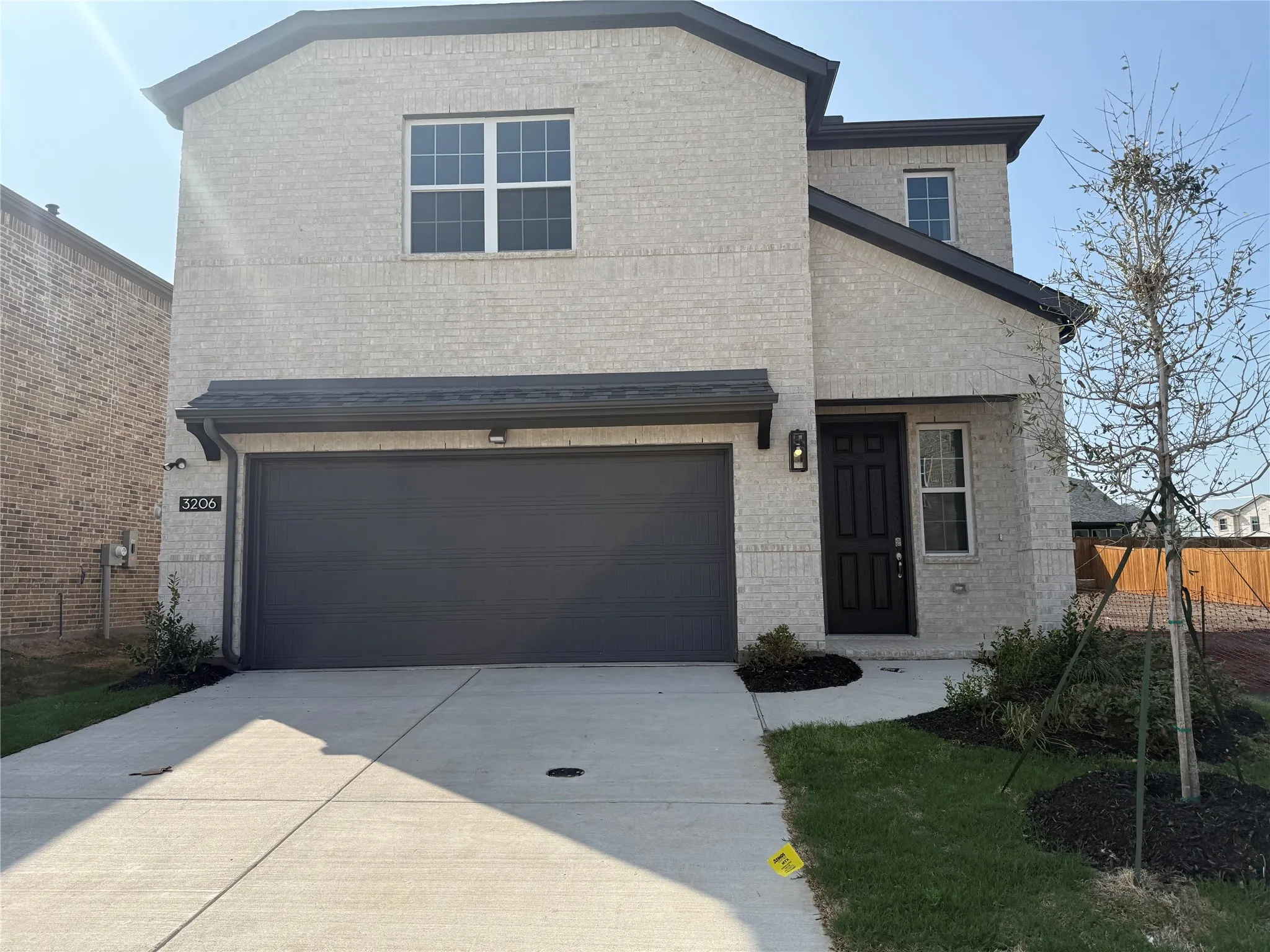 Brick exterior with dark trim and black garage door