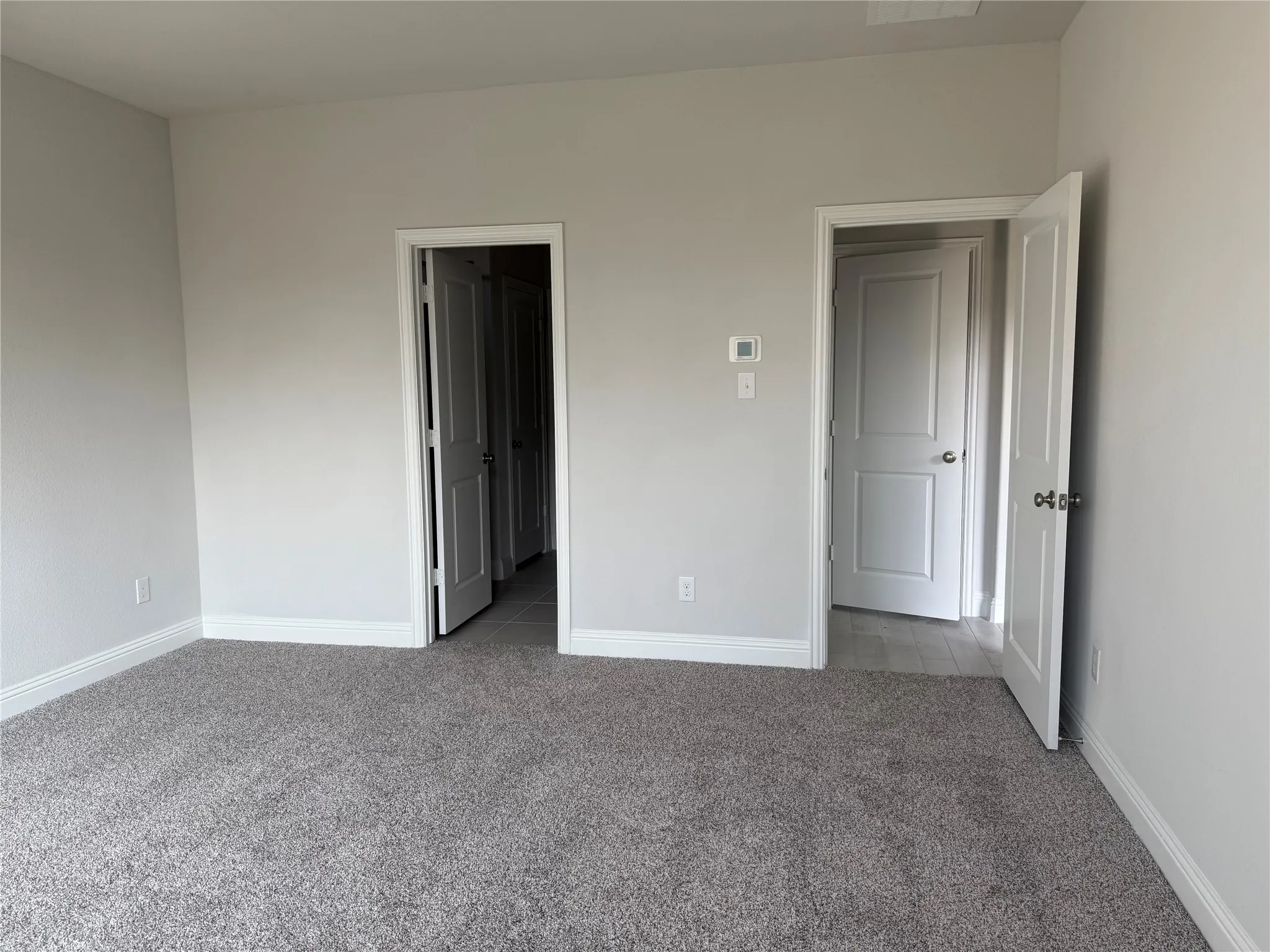 Plush carpeting, light-toned walls, and white trim throughout