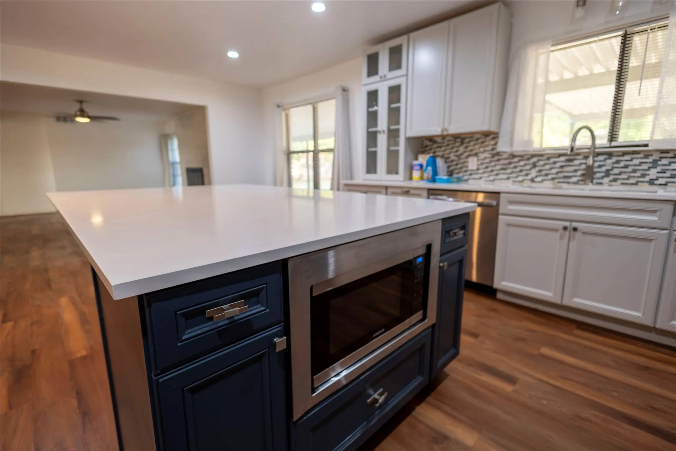 Spacious kitchen island with a white countertop and built-in microwave