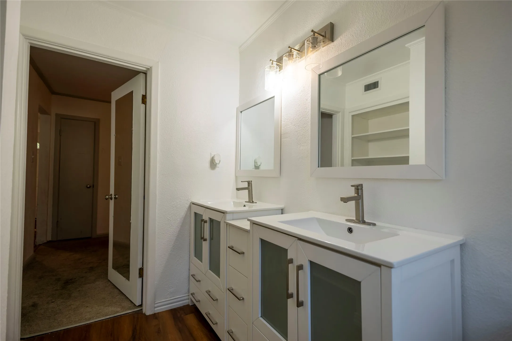 Dual vanity featuring undermount sinks, white countertops, and brushed nickel fixtures